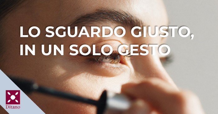 Primo piano di un occhio con ciglia definite da mascara e tubetto sfocato in primo piano
